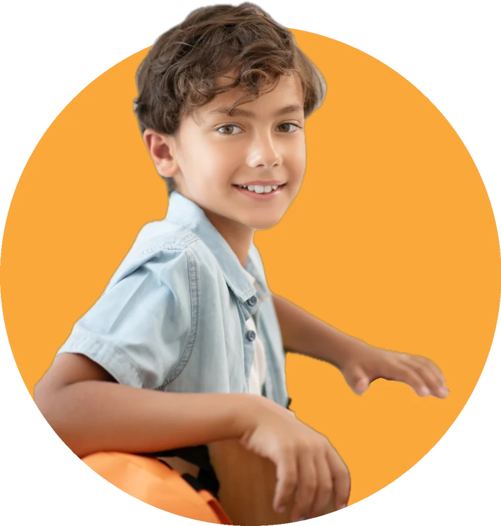 Menino sorrindo sentado na carteira escolar