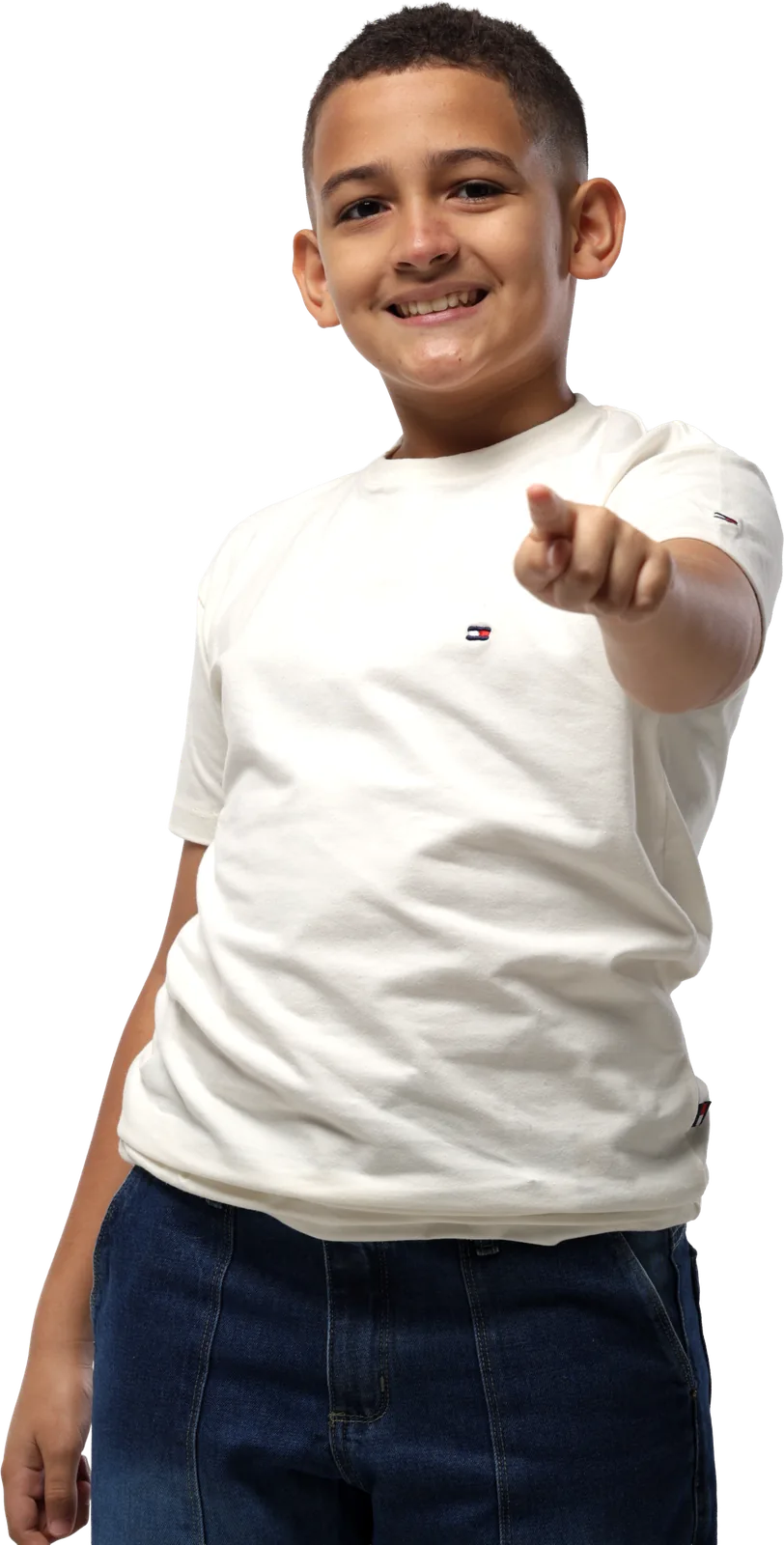 Menino de camiseta branca sorrindo e apontando para o lado